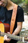 Man playing guitar using Cascadia leather guitar strap