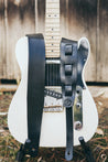 Hand-crafted black leather guitar strap shown on guitar