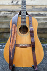 Hand carved feather guitar strap shown on guitar
