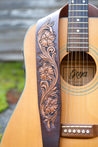 Close up detail of hand-carved and dyed Sheridan rose design on leather guitar strap
