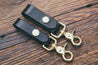 Black leather key fobs with solid brass trigger snap, shown in two widths: 3/4" and 1"