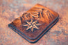 Front detail of hand-tooled wallet showing compass rose, mountain range and polished wallet edges