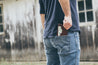 Man placing handcrafted leather wallet into the back pocket of his jeans