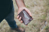 Man holding folded Hexa Six Pocket leather wallet