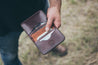 Interior of four pocket wallet handcrafted with Mahogany leather. Wallet filled with credit and debit cards and cash