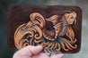 Detail shot of handcrafted leather wallet with Koi design hand-tooled on the front