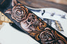 Close up detail of hand-carved skull, roses and scrollwork on leather guitar strap