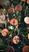 Decorative handcrafted leather ornaments with embossed designs on a Christmas tree.