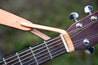 Hand-crafted leather adapter strap shown on guitar neck is attached a standard guitar strap, allowing it to be used even on guitar with only one button. 