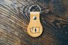 Hand-crafted leather key fob with Washington state outline and single pine tree design embossed on front