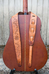 Leather guitar strap with hand tooled topographic mountains and compass rose shown on guitar 