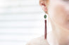 Model wearing handcrafted leather fringe earrings with oval Jade bead
