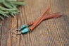 Turquoise & Leather Fringe Earrings lying on wooden background.