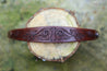 Detail of hand carved scrollwork on leather cuff bracelet