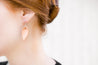 Natural Small Leather Petal Earrings shown on model's ear