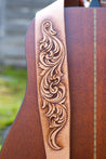 Detail of hand carved and hand tooled leather scrollwork on guitar strap