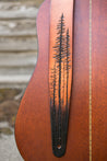 Details of hand carved and tooled lodgepole pine forest on leather guitar strap