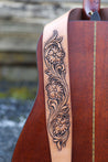 Details of hand carved scrollwork and flowers on Antiqued Sheridan Rose leather guitar strap