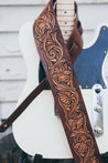 Close up detail of hand-carved and dyed Sheridan roses and scrollwork on leather guitar strap