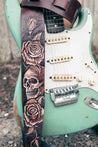 Close up detail of hand-carved and dyed skull and roses on leather guitar strap