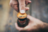 Close up detail of mountain bottle opener key fob cracking open a bottle of beer