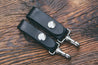 Black leather key fobs with stainless steel spring clip, shown in two widths: 3/4" and 1"