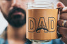 Man with mustache and beard holding leather DAD mug. 