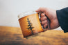 Lodgepole pine tree leather mug held in man's hand. 
