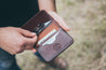 Man pulls card from interior of handcrafted leather wallet
