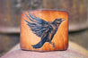 Handcrafted leather wallet with tooled design featuring a large raven across the front of the wallet